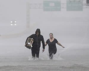 Two people walk down a flooded section of Interstate 610 in floodwaters from Tropical Storm Harvey on Sunday, Aug. 27, 2017, in Houston, Texas. (AP Photo/David J. Phillip)