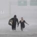Two people walk down a flooded section of Interstate 610 in floodwaters from Tropical Storm Harvey on Sunday, Aug. 27, 2017, in Houston, Texas. (AP Photo/David J. Phillip)