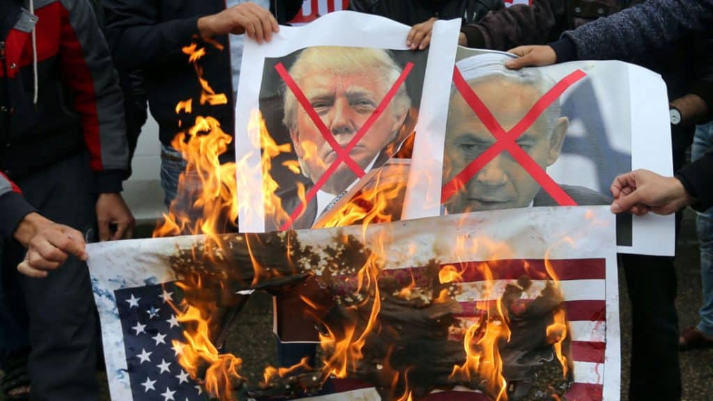 Palestinians burn posters depicting Netanyahu and Trump during a protest against the U.S. intention to move its embassy to Jerusalem and to recognize the city of Jerusalem as the capital of Israel, in Rafah in the southern Gaza Strip