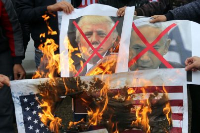 Palestinians burn posters depicting Netanyahu and Trump during a protest against the U.S. intention to move its embassy to Jerusalem and to recognize the city of Jerusalem as the capital of Israel, in Rafah in the southern Gaza Strip