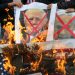 Palestinians burn posters depicting Netanyahu and Trump during a protest against the U.S. intention to move its embassy to Jerusalem and to recognize the city of Jerusalem as the capital of Israel, in Rafah in the southern Gaza Strip