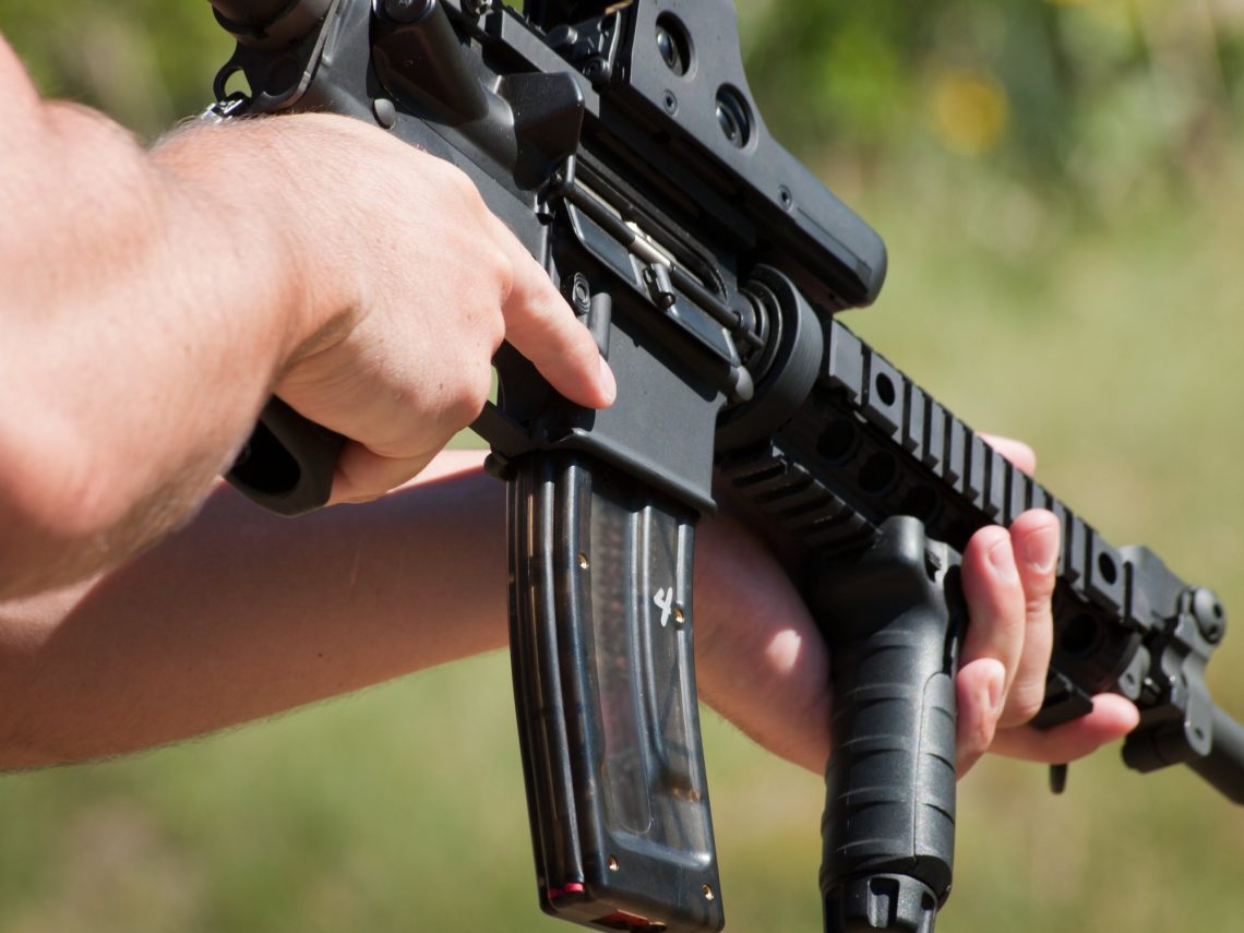A man target shooting at a gun range