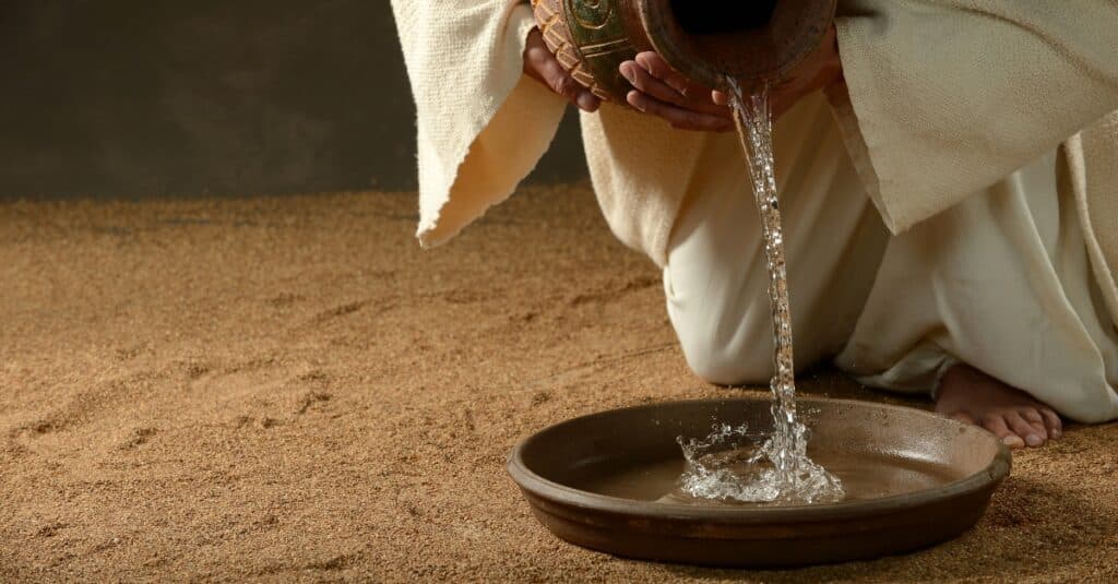 Jesus pouring water from a jug (with copyspace for text)