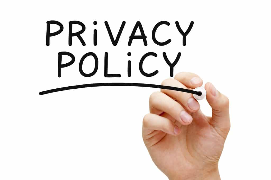 Hand writing Privacy Policy with black marker on transparent wipe board.